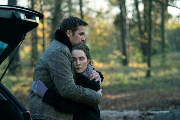 James D’Arcy and Noomi Rapace in hugging outside.