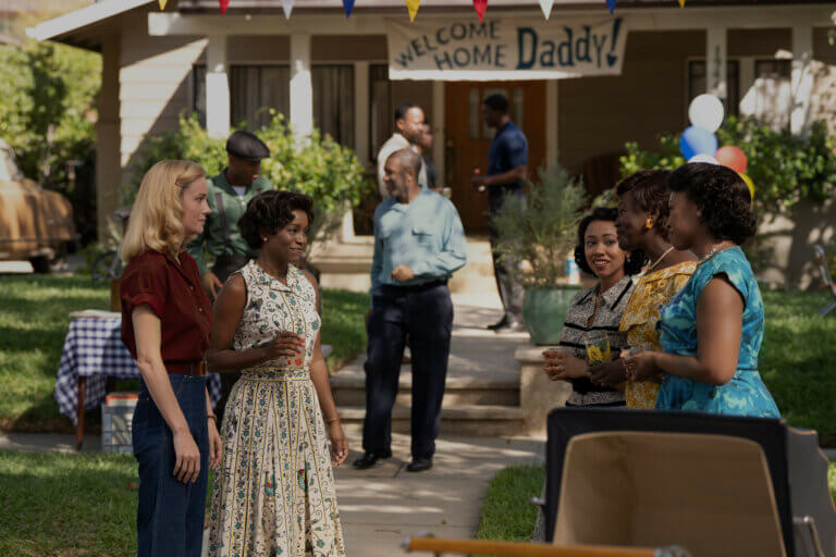 Aja Naomi King and Brie Larson in 50s clothing outside talking to people.