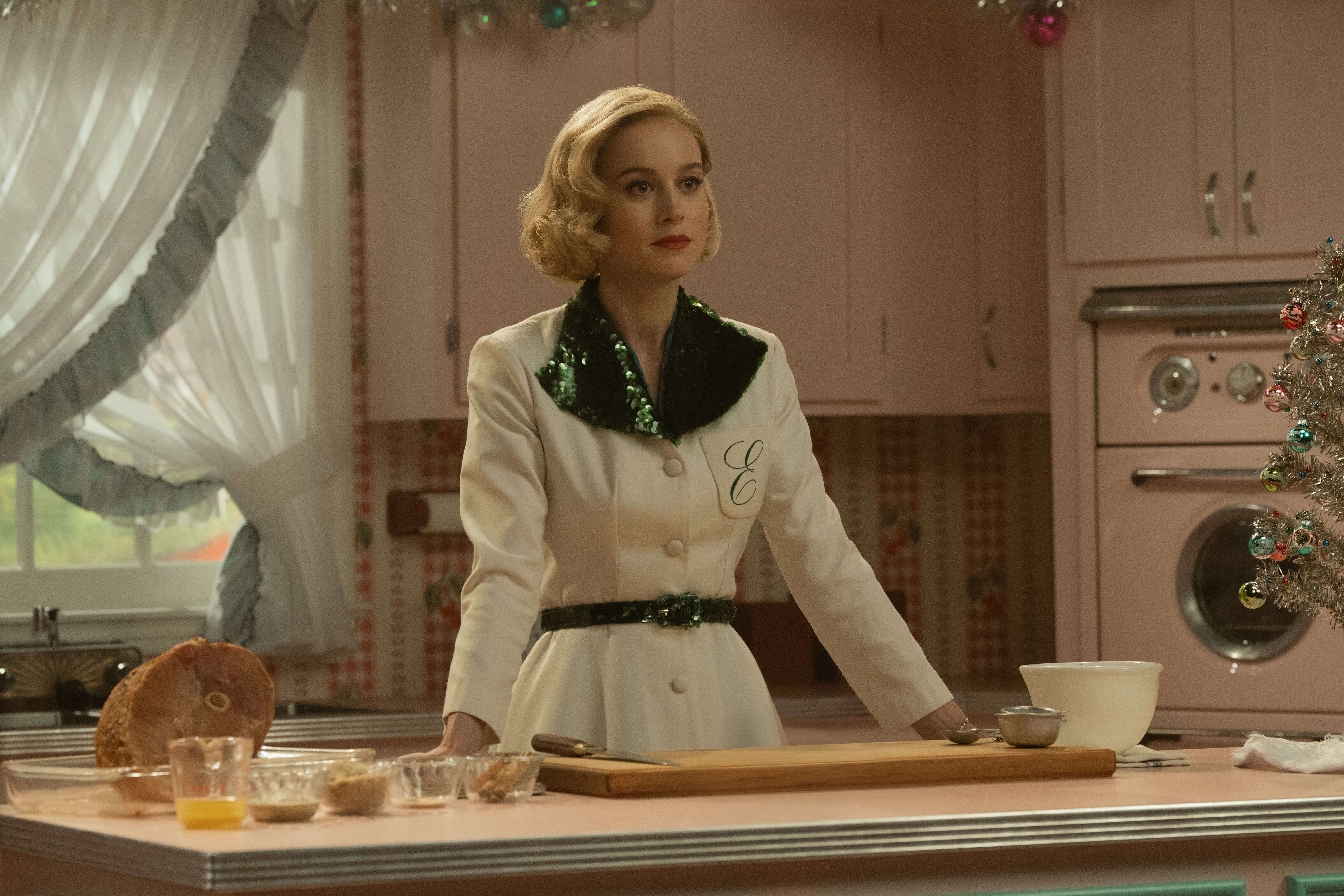 Brie Larson in a white 1950s shirt in the kitchen cooking.