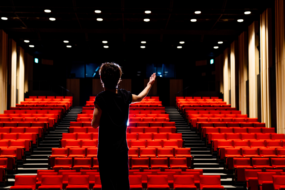 Young actor singing in an empty theater.