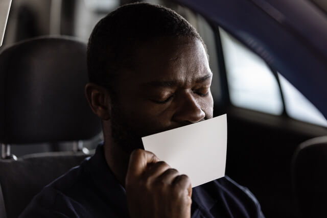 David Oyelowo, sad and sitting in his car holding a letter.
